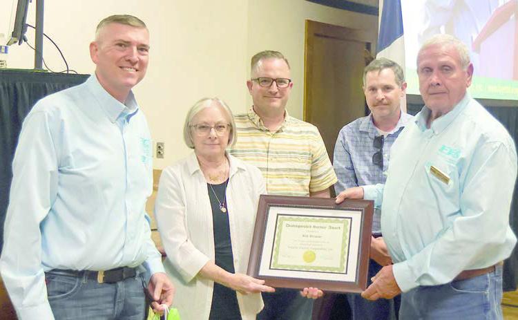 Bill Brisco e, a 19-year director who died in February, was remembered by the board. FEC representatives and Briscoe family members shown with a distinguished service award given in his honor and a token of appreciation from the cooperative are (from left) FEC General Manager/CEO Doug Lambert; Mrs. Patricia Briscoe and her sons Corey Briscoe and Tyson Briscoe; and FEC board president Joseph Kruppa.