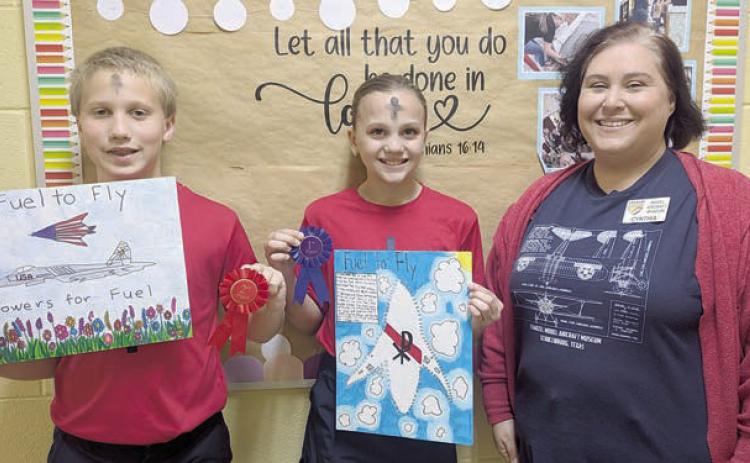 ST. Rose winners – Addison Ann Zita Johnson (center), first place; and Brennen Berger (left), runner-up. Representing Stanzel Model Aircraft Museum is director Cynthia Fogleman (right).