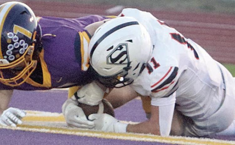 Nick Goode snatches the ball away from Cayden Conway in the end zone after an errant punt snap to give the Horns their only touchdown. Sticker Photo By Darrell Vyvjala