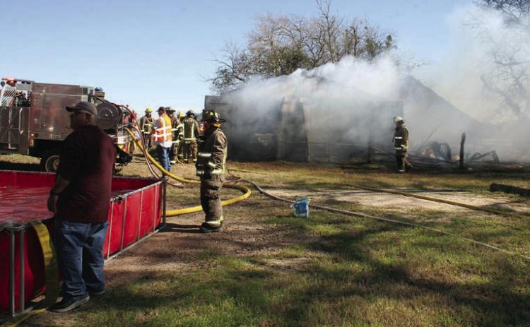Smoke billows from the barn north of town as SVFD personnel use a “dump tank” (left) to keep water flowing as they put out the fire last Friday. Sticker Photo By Darrell Vyvjala