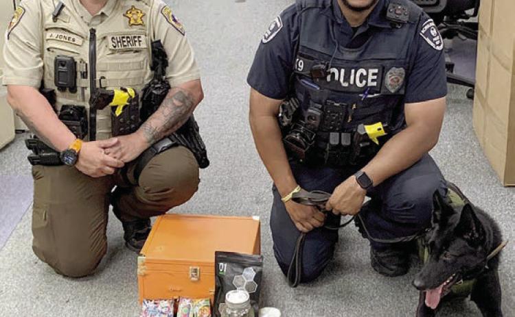 Sheriff’s Department Deputy Josh Jones (left) and Schulenburg Police Department Officer Byron Powe with his canine partner, Semper, are shown with the items found after a traffic stop last Wednesday on Highway 71.