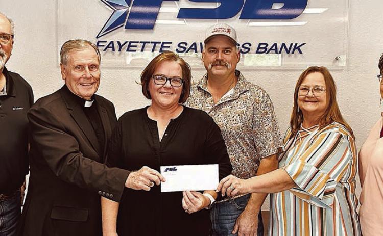 The Matching Funds Campaign at Fayette Savings Bank for St. Rose School renovations has received a $5,000 donation from Misty and Colin Ohnheiser (center). Also shown are (from left) Mike Olle, Fayette Savings Bank; Very Rev. Jasper Liggio, St. Rose of Lima Catholic Church pastor; (continuing after the Ohnheisers) Rosanne Gallia, St. Rose School principal; and Cheryl Brossmann, Fayette Savings Bank lobby manager.