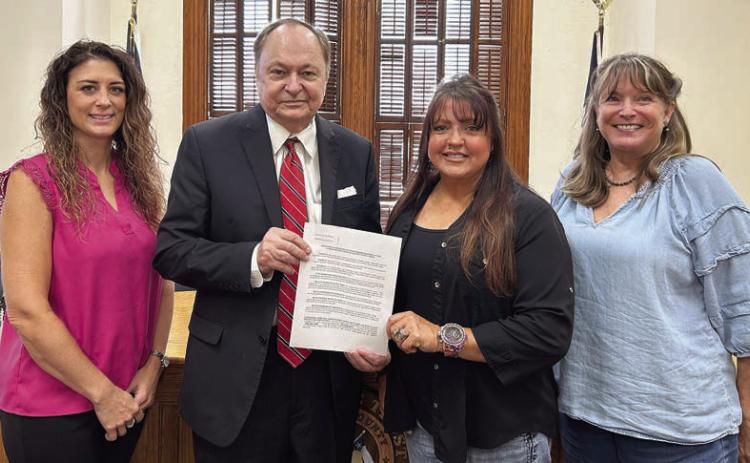 The Resolution regarding wind turbines, signed at the Fayette County Commissioners Court meeting on Aug. 8, was presented by County Judge Dan Mueller (second from left) and Court Administrator Cassie Austin (left) and accepted by T.J. “TJ Mac” McCleney (second from right) of Swiss Alp and Wendy Syrinek (right) of Middle Creek.