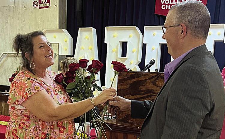 Donna Kunz (left) receives the last of 40 roses representing her 40 years at St. Rose from her husband, Darren.