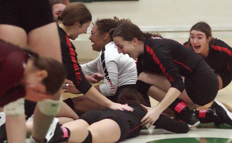 Lady Horn players drop to the floor in elation after securing the Class 2A Region IV championship Saturday afternoon. Sticker Photo By Darrell Vyvjala