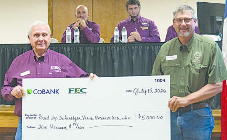 Round Top Schuetzen Verein Preservatio n Inc. received $5,000 for renovation projects at its historic hall. Shown are (foreground, from left) FEC board president Joseph Kruppa; and Michael Sacks, vice president of community affairs for Round Top Schuetzen Verein Preservation Inc.