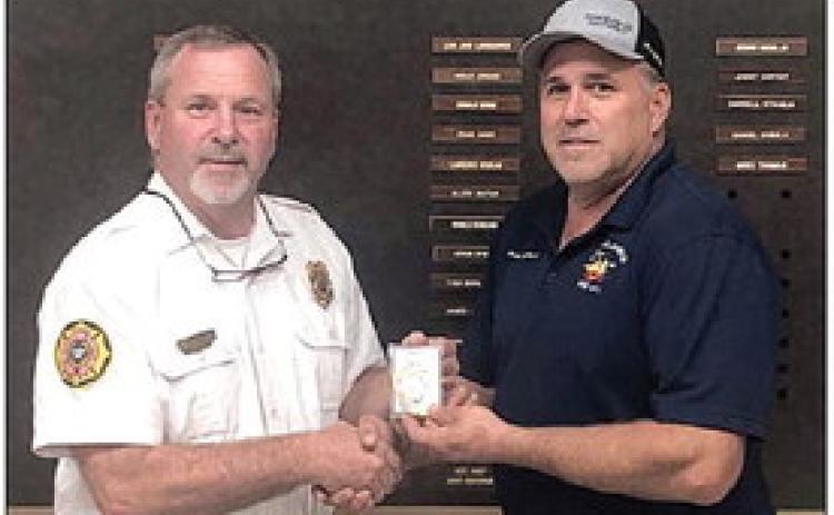 Jeff Proske (left) presents Darren Guentert with his chief’s badge at last week’s SVFD meeting.