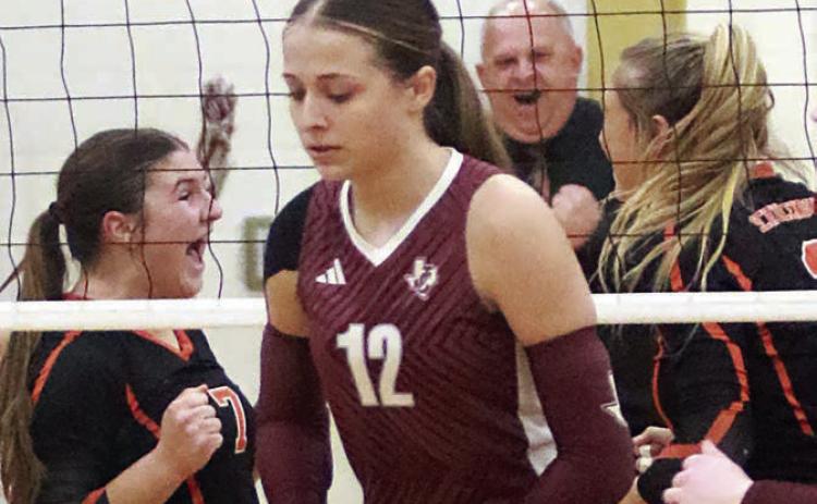 Behind a dejected Johnson City player, Landry Zapalac (left) celebrates with Reagan Dusek (right) after their block closed out the match while head coach Donald Zapalac shows his jubilation in the background. Sticker Photo By Darrell Vyvjala