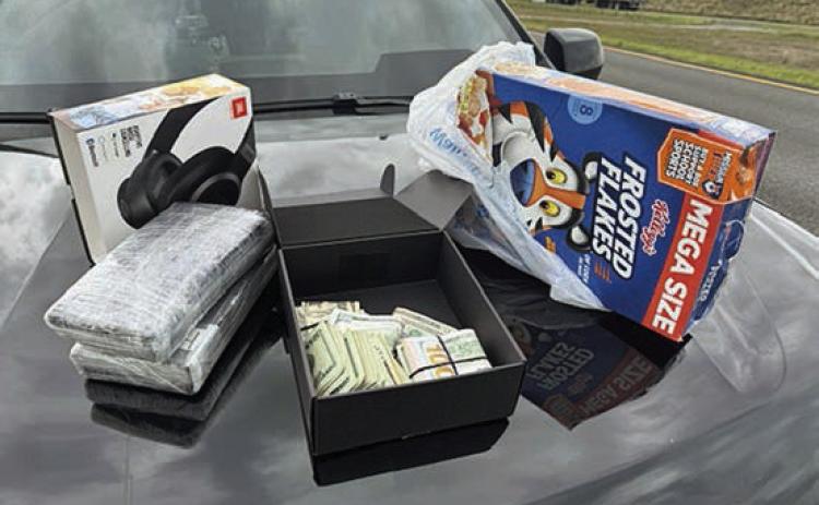 Shown above are the two kilos of cocaine and the cereal box in which they were located along with the $10,000 cash was found inside a headphones box.