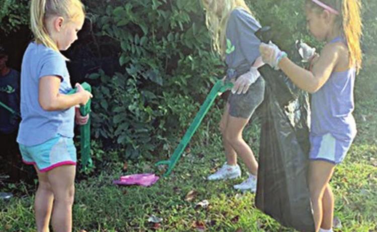 Chandler Bubela (front, left), Ella Banse (front, right), and Brynn Bubela help pick up trash as part of Keep Schulenburg Beautiful’s Fall Sweep.