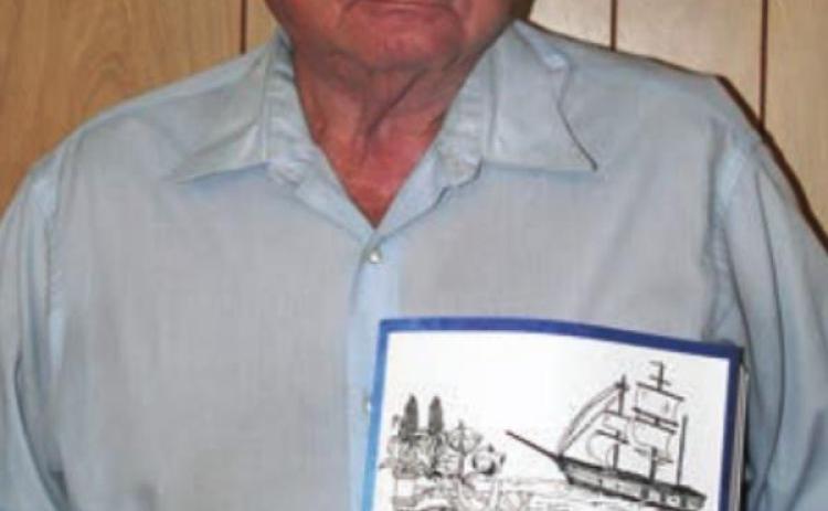 Ed Janecka shows off his book on the history of Dubina. Sticker Photo By Darrell Vyvjala