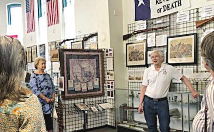 Docent Charles Murray (standing in back) explains significance of wall items at the Texas Heroes Museum in La Grange to a tour group from them Fayette County Retired Teachers’ Association.