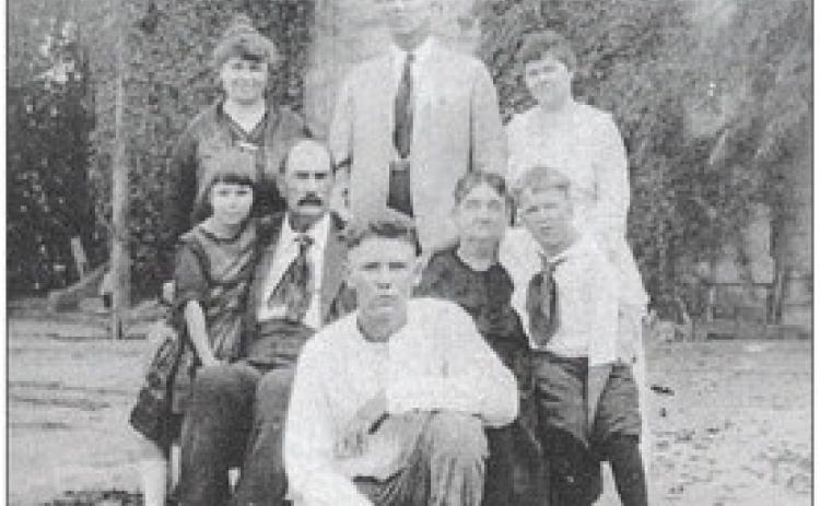 Loessin family at Fayette County Jail, circa 1919. Standing are Katie (Stiehl) Loessin, Will Loessin, and an unidentified woman. Seated are Ruth, August and Louise Loessin, and an unidentified young boy. In front is Wilburn Loessin. Photo Courtesy of Fayette Heritage Museum &amp; Archives
