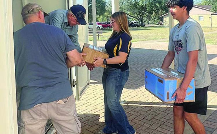 (from left) Jack Niesner and Ken Berger from the SAFP and NHS members Kyrroll Prihoda and Edgar Mandujano load boxes of items from the food drive into the trailer.