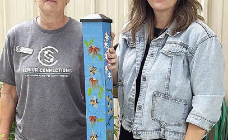 garden pole delivery continues. Jill Walles (right) receives this beautiful pole painted by Berni Gillings from Stephanie Shroyer (left), program director. Walles is the executive director of the Flatonia Chamber of Commerce, and Senior Connections appreciates the support through weekly e-news blasts for its programs in this active community.