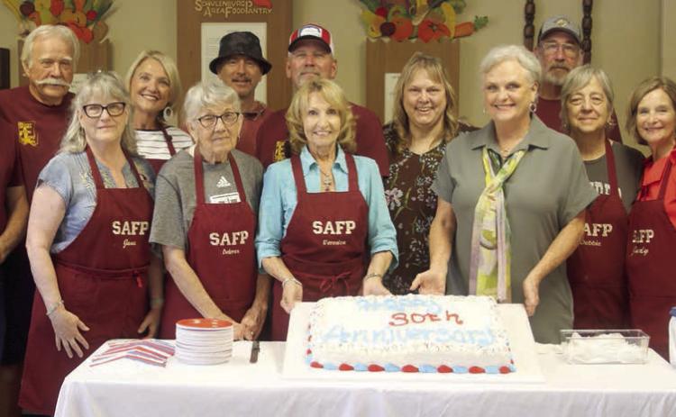 Schulenburg Area Food Pantry board members and volunteers on hand at last week’s 30th anniversary open house were: (front from left) Jana Semler, Delores Michalke, Veronica Smith, Debra Blansitt, Debbie Behlen, Judy Janik; (back, from left) Bill Michalke, Dallas Canada, Sue Broadwater, Ed Semler, Gerald Smith, Sheila Brossmann, Kenneth Behlen, and Jack Niesner. Sticker Photo By Darrell Vyvjala