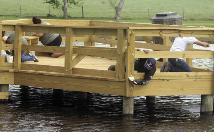 Sour LCRA employees apply sealant to the City’s newly-constructed pier at the Sports Complex last Friday morning. Sticker Photo By Darrell Vyvjala