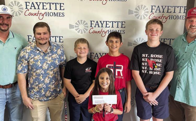 Representatives of Fayette Country Homes and Adamek Rentals LLC, shown with St. Rose students, are (front) Emma Zweschper; (back row, from left) Dalton Friedrich and Dalton Manning, representing Fayette Country Homes; Brody Brossmann, Dylan Zweschper and Bo Brossmann; and Gary Adamek, owner of Fayette Country Homes and Adamek Rentals, LLC