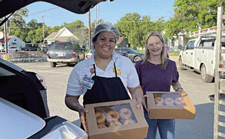 Loading up donuts for National Donut Day distribution to Fayette County first responders are Claudia Reyes (left), La Grange H-E-B bakery manager, and Krystal Seger (right), Fayette County Salvation Army Chapter board member.