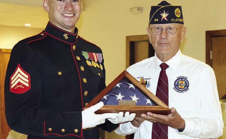 Flatonia American Legion Post 94 Commander Danny Vyvjala (right) presents a folded flag to the youngest veteran in attendance, 29-year-old Montana Olle of Schulenburg (left). Photo By Melanie Berger / Courtesy of Flatonia Argus