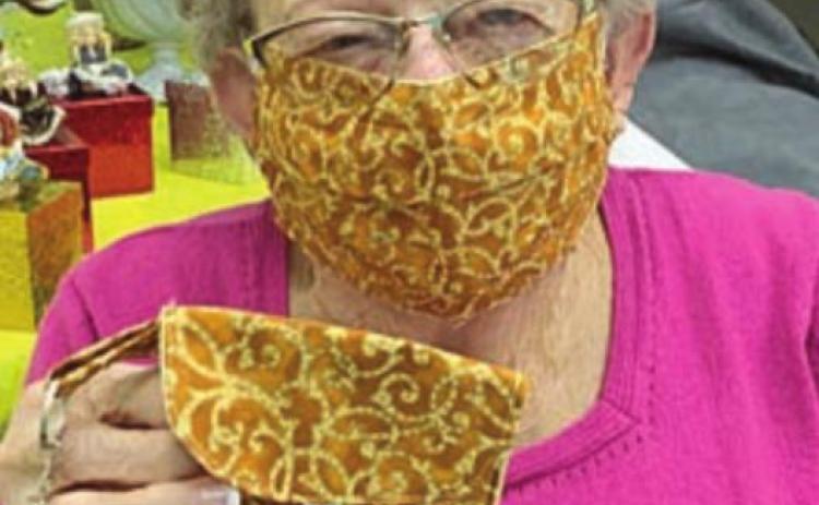 MATCHING MASK &amp; PURSE – Navidad Valley Community Connections member Irene Janda wears a mask and holds the matching purse. The purse is only the size of a folded mask, and attaches to a regular purse, belt or backpack. The matching masks and mini-purses are available by contacting NVCC.
