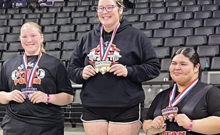 Cora Brenek (center) stands atop the medal stand following her statequalifying performance at the regional meet.
