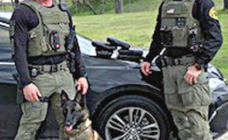 Sgt. Randy Thumann, his K-9 partner Kolt and Investigator David Smith with 5.45 kilos of cocaine recovered after Sgt. Thumann initiated a traffic stop on a black Toyota Camry on Interstate 10 near Flatonia. The driver sped off and during an 11-mile pursuit, threw bricks of cocaine out the window.