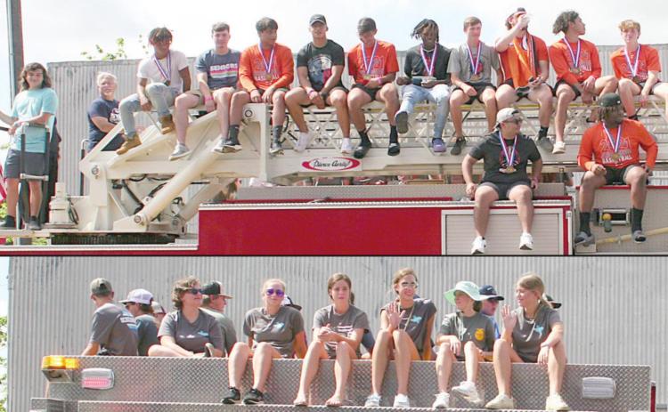 Schulenburg High students who qualified for state or won state titles ride atop Schulenburg Volunteer Fire Department trucks as parade marshals Sunday morning. Sticker Photos By Darrell Vyvjala