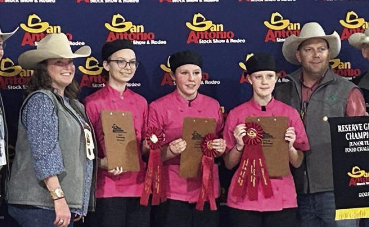 Simmer Do wn – (from left, flanked by two San Antonio Livestock Show representatives on each side) Tatum Fritsch, Ally Kibby and Sawyer Mau. The team won reserve champion in the junior division.
