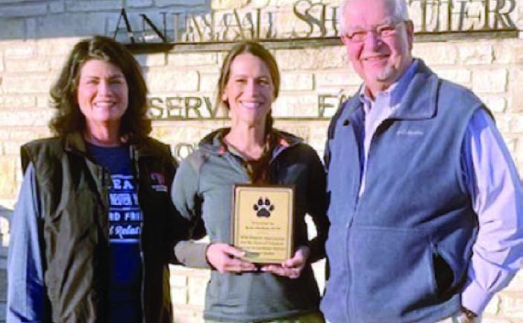 A plaque is presented to Dr. Rylee Hatfield (center), board president of the Gardenia E. Janssen Animal Shelter since 2019, by Teresa Brown (left), GJAS executive director, and Frank Reichert (right), GJAS poard president elect.