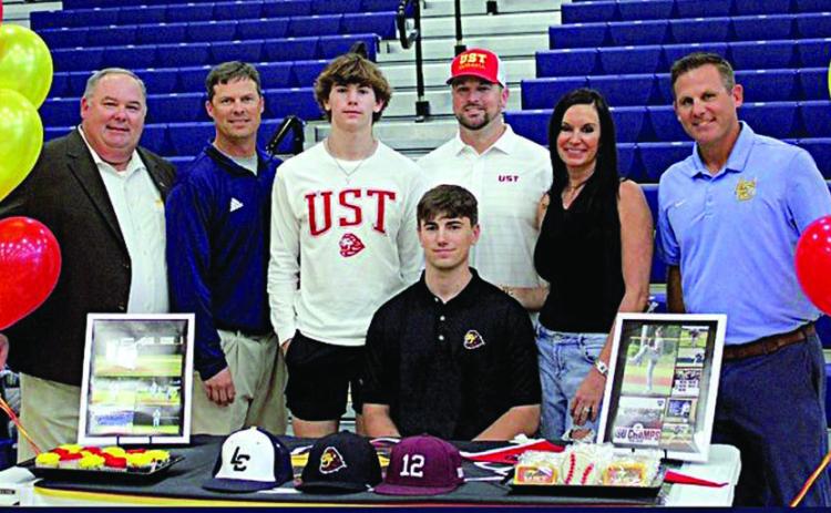 Jaxson Hanel (seated), a senior at Lake Creek High School in Montgomery ISD, signed a letter of intent on Wednesday, Nov. 8 to play baseball for the University of St. Thomas in Houston. Hanel is the grandson of Harlan and Betty Guettermann of Schulenburg. Also shown at the signing are his parents, Lisa and Mark Hanel (second and third from right); his brother Austin (third from left); Lake Creek High School principal Tim Williams (left); and his two coaches (right and second from left).