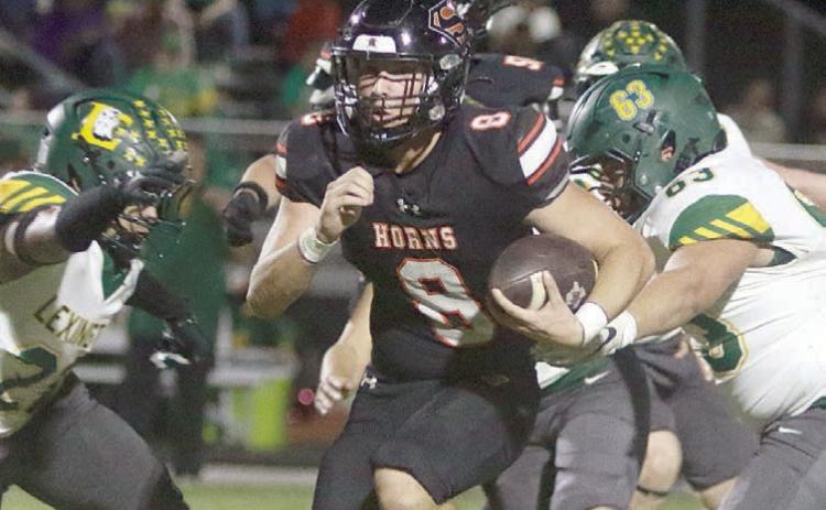 Owen Brenek gets by a pair of Eagle defenders on his way to a 24-yard touchdown run in the first quarter. Sticker Photo By Darrell Vyvjala