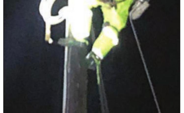 Apprentice Lineman Joey Jasek climbs a pole during the night to pull wire to complete repairs on a downed power line north of Weimar. Photo By FEC Line Foreman Greg Noak