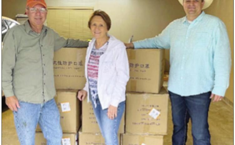 Harlan and Joyce Kobza (left) and Fayette County Emergency Management Coordinator Craig Moreau pose with the boxes of masks that were gifted to Fayette County by the Kobza’s son, Carman.