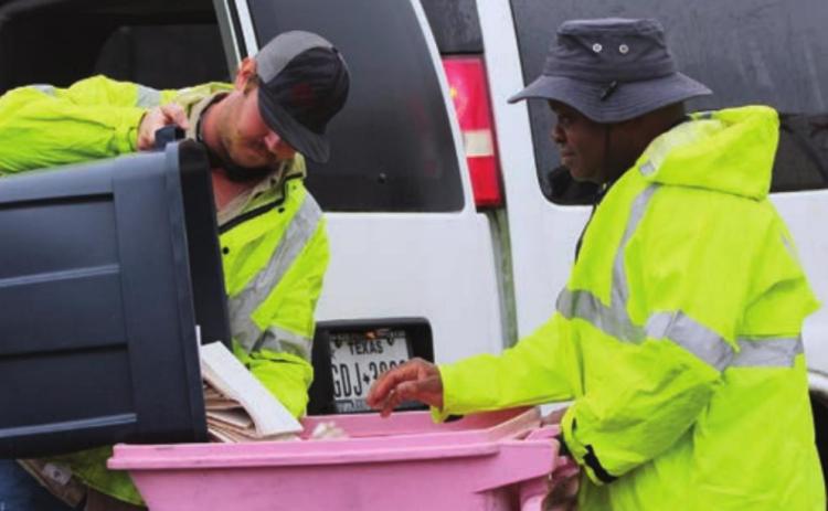 FAYETTE ELECTRIC COOPERATIVE groundman Justin Neiser dumps FEC member documents into a container for ProShred’s Terry McCoy to place in the shredding truck.
