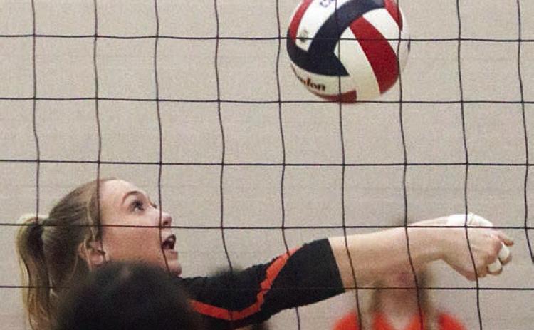 Reagan Dusek saves a ball near the net in the second set. Sticker Photo By Darrell Vyvjala