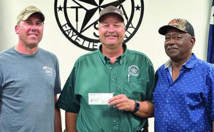 Schulenburg Economic Development Corporation President Paddy Magliolo (left) and Treasurer Ed Glass (right) present a $220,000 check to City Operations Manager Darryl Moeller. The funds will go toward paving at the Civic Center as well as on Matula, Kueper, and Avenue and B ($70,000) along with sewer line relocation and line replacement on College Street ($150,000.