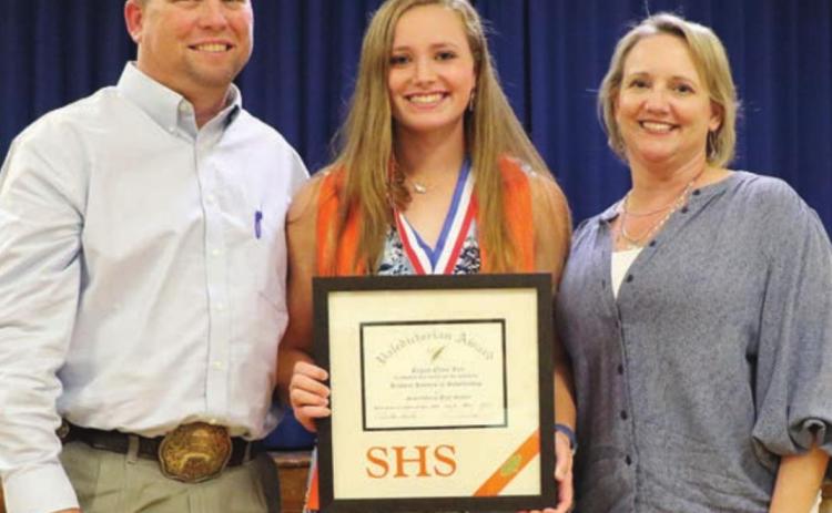 Regan Lux (center) accepts the valedictorian plaque at the academic banquet with her parents, Brad and Terah alongside. Photo By Audrey Kristynik