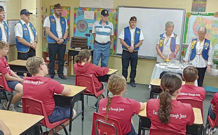 Members of the Legion Auxiliary and American Legion shown holding the POW/MIA ceremony at St. Rose of LIma Catholic School are (standing in back, from left) Wesley Holub, Eugene Krupala, Jack Niesner, Rick Todd, James Brown, Jesse Lednicky, Debbie Behlen, Patricia Hranicky and Barbara Brown.