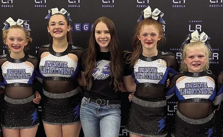 Blue Light ning elite all-star cheer team and coaches include (from left) Addisan Wagner-assistant coach, Lexi Pilat, Lennon Demel, Ava Baladez, Emily Garza-head coach, Paisley Baladez, Brooklyn Beeman, Bebe Pavlica and Avalon Saavedra-assistant coach. The Baladez sisters attend Schulenburg ISD. Sticker Photo By Diane Prause