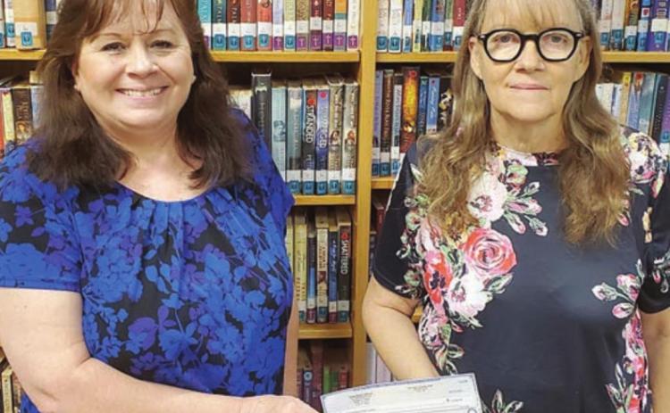 Assistant Librarian Donna Holub (left) and Librarian Cindy Lytle accept the $2,500 check that was received through a grant from the Texas Book Festival.
