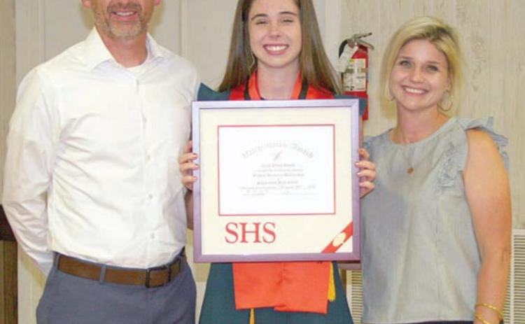 Claire Antosh (center) accepts the valedictorian plaque at the Senior Scholarship and Academic Banquet earlier this month with her parents, Michael Antosh and Erin Bonner. Sticker Photo By Darrell Vyvjala
