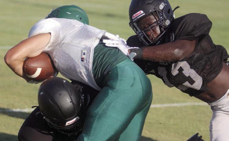 Rodney H Walton (right) and Byron Johnson combine to bring down a Lexington Eagle in last Thursday’s scrimmage. Sticker Photo By Darrell Vyvjala