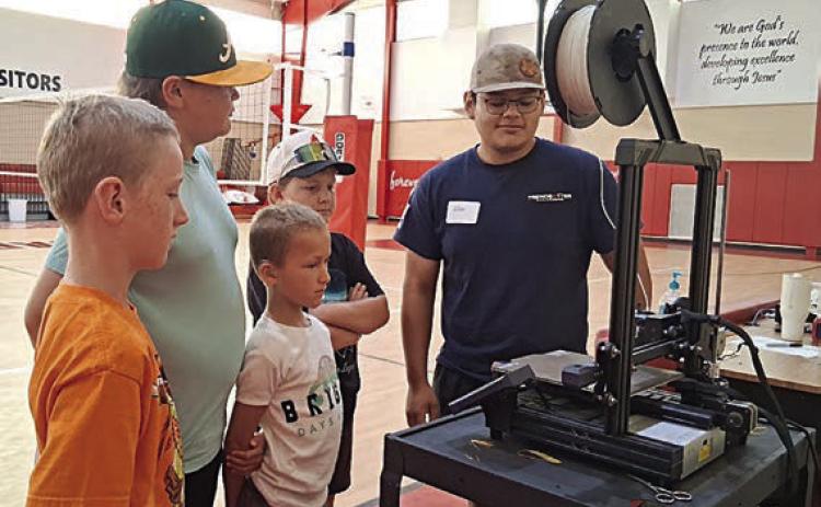 A 3D printer and how to program it is being demonstrated by Noe Nieto (right).