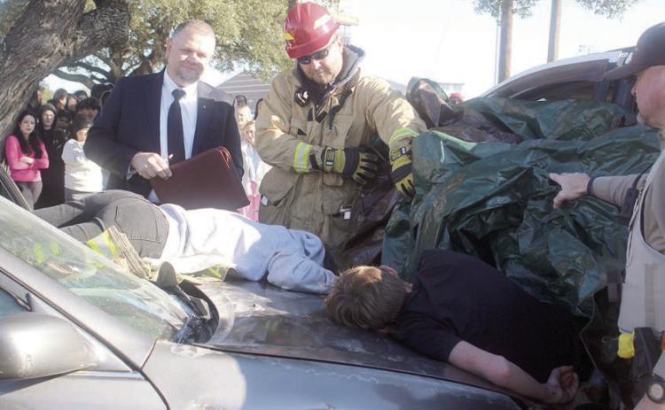 Fayette County Precinct 4 Justice of the Peace Paul Zapalac (left) conducts an inquest, resulting in the death pronouncements for the two ejected accident victims. Assisting him at the mock scene were Schulenburg Volunteer Fire Department First Assistant Chief Drew Brossmann (center) and Fayette County Sheriff’s Department Deputy Rick Bohlmann (right). Sticker Photo By Darrell Vyvjala