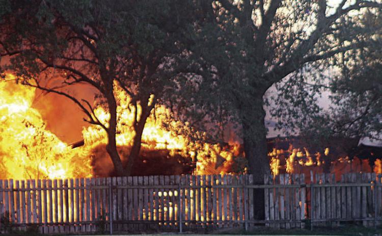 Flames totally engulf the outbuilding at 507 Bucek St. Sticker Photo By Darrell Vyvjala