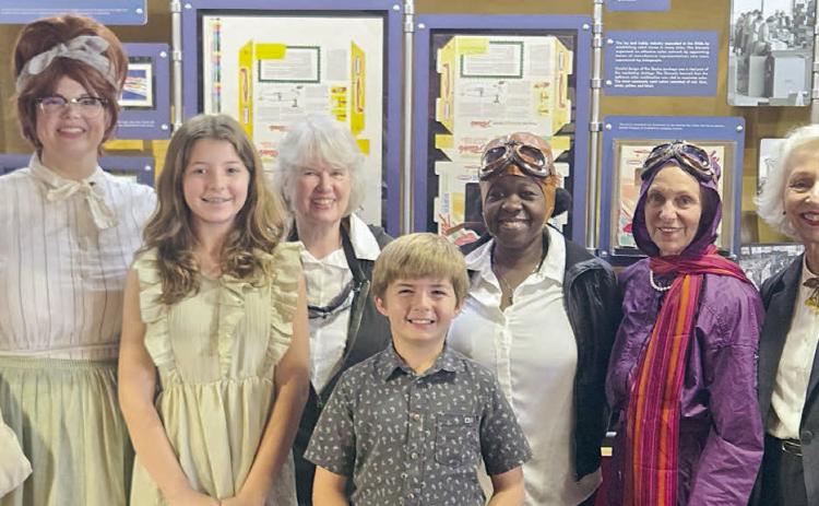 Performing in “Wings of Their Own: Influential Women in Aviation” were (front row, from left) Remi Denham, Tucker Denham, (back row) Kristen Graeter Holub portraying Dorothy Schmidt, Elota Patton portraying Evelyn “Bobbi” Trout, Rebecca Powe portraying Bessie Coleman, Jaci Elliott portraying Harriet Quimby and Janis Richardson portraying Sophie Mühlstein.