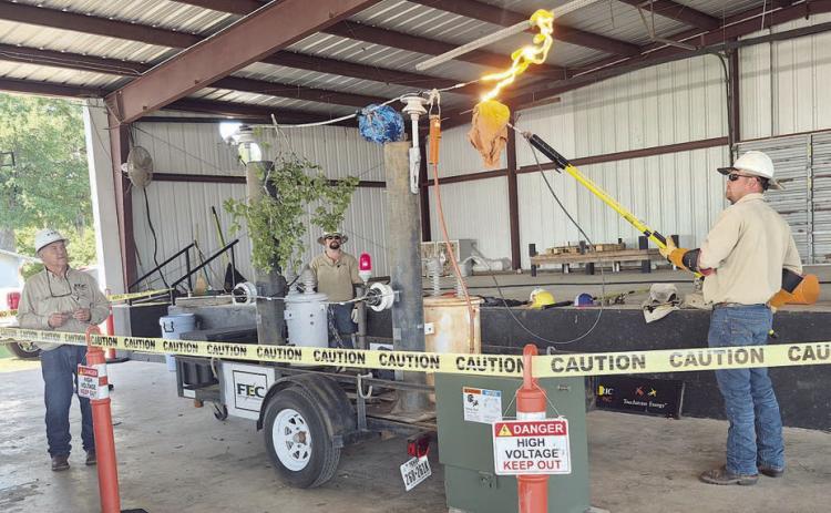 Fayette Electric Cooperative safety compliance director Larry Sulak (left), journeyman lineman Justin Whited (center) and lineman apprentice Clayton Brossmann (right) demonstrate electrical safety during Progressive Ag Safety Day at the Fayette County Fairgrounds in La Grange on Monday, May 4, which was attended by area fifth-grade students. The hands-on presentation highlighted the dangers of electricity and ways students can stay safe around power lines and at home.