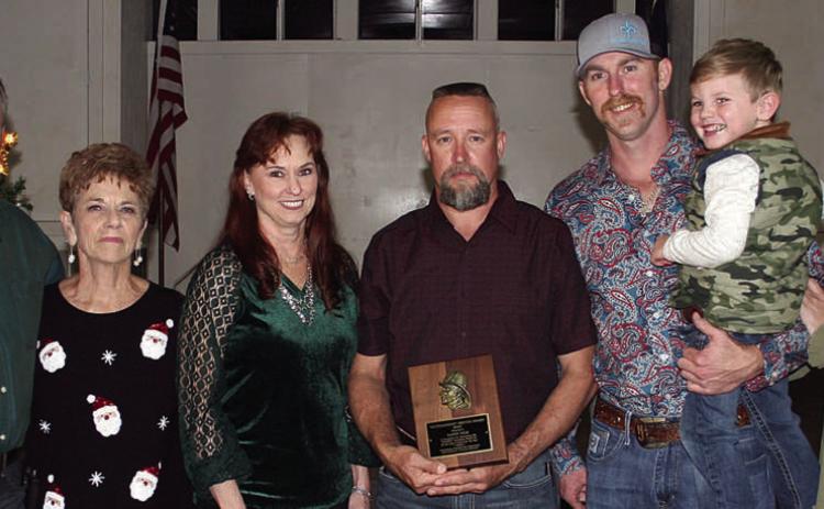 OUTSTANDING SERVICE – Second Assistant Chief Randy Wick (center) receives the Outstanding Service Award for 2022 for making the highest percentage of calls, meetings, and drills at 89 percent. The award is sponsored each year by the family of the late Chief Roland Proske. Making the presentation were (from left) Jeff, Pat, and Terry Proske along with Doran Proske (third from right), Kelsey Svetlik (right), and Kelsey’s son, Will. Sticker Photo By Darrell Vyvjala