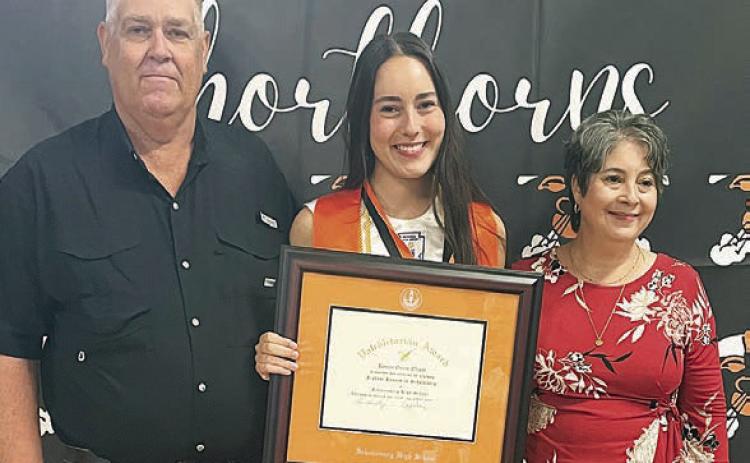 Kenna Oliver (center) receives the valedictorian plaque and medal with her parents, Wesley and Carrie Oliver, alongside at the Senior Scholarship Banquet. Sticker Photo By Darrell Vyvjala